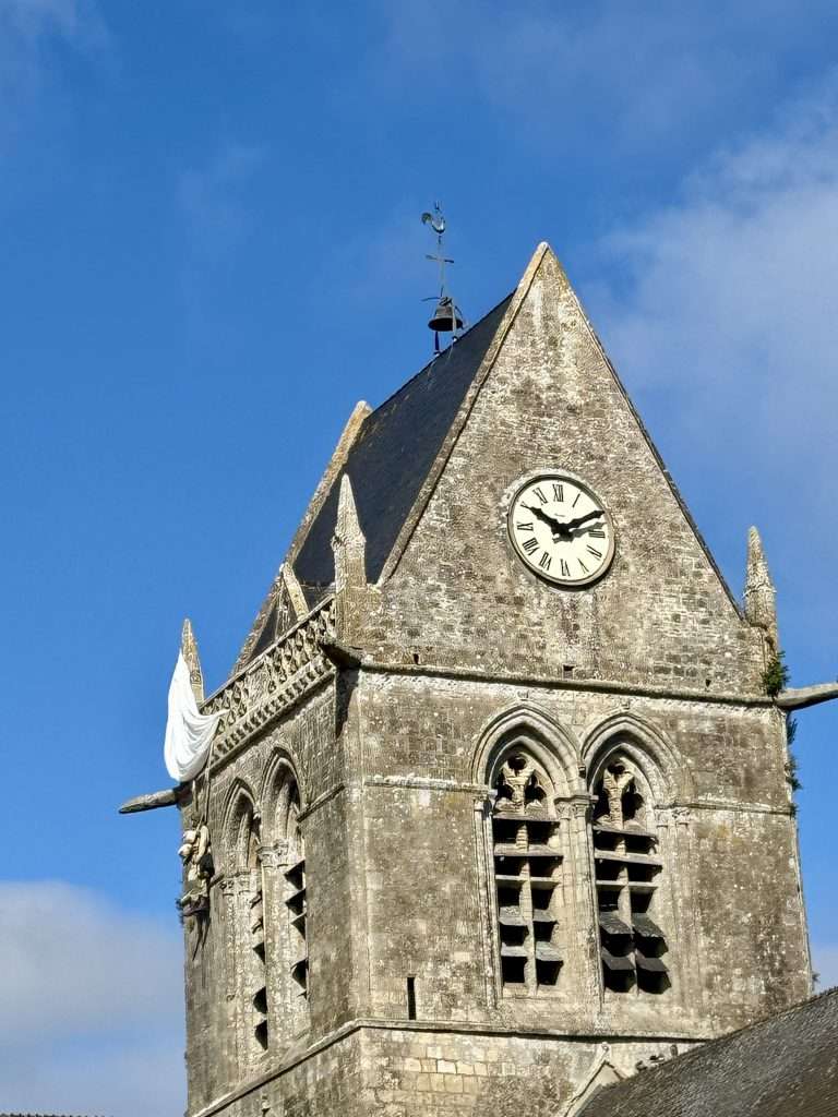 Private John Steele - replica of Parachute snagged on the steeple of the church at Sainte-Mère-Eglise in Normandy